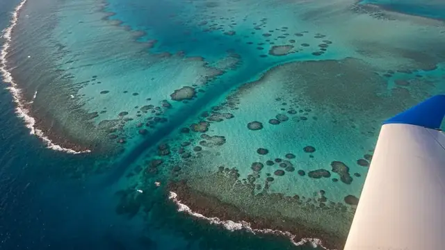 Aerial view of Great Barrier Reef with aircraft wing